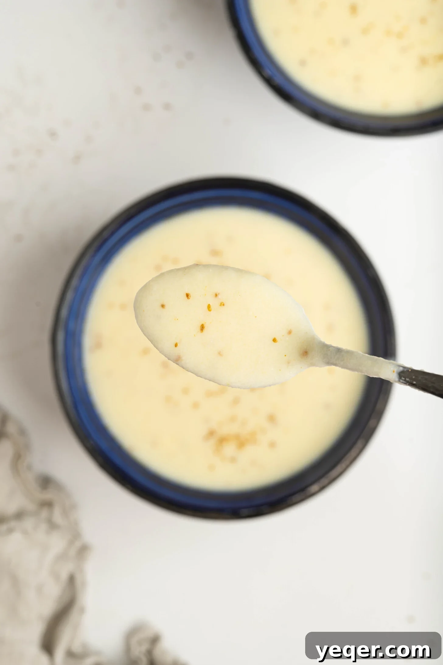 Baba's Moroccan Semolina Cold Remedy 8 A beautifully presented bowl of Moroccan semolina soup, garnished with a light drizzle of olive oil and a sprinkle of anise, poised on a rustic table.
