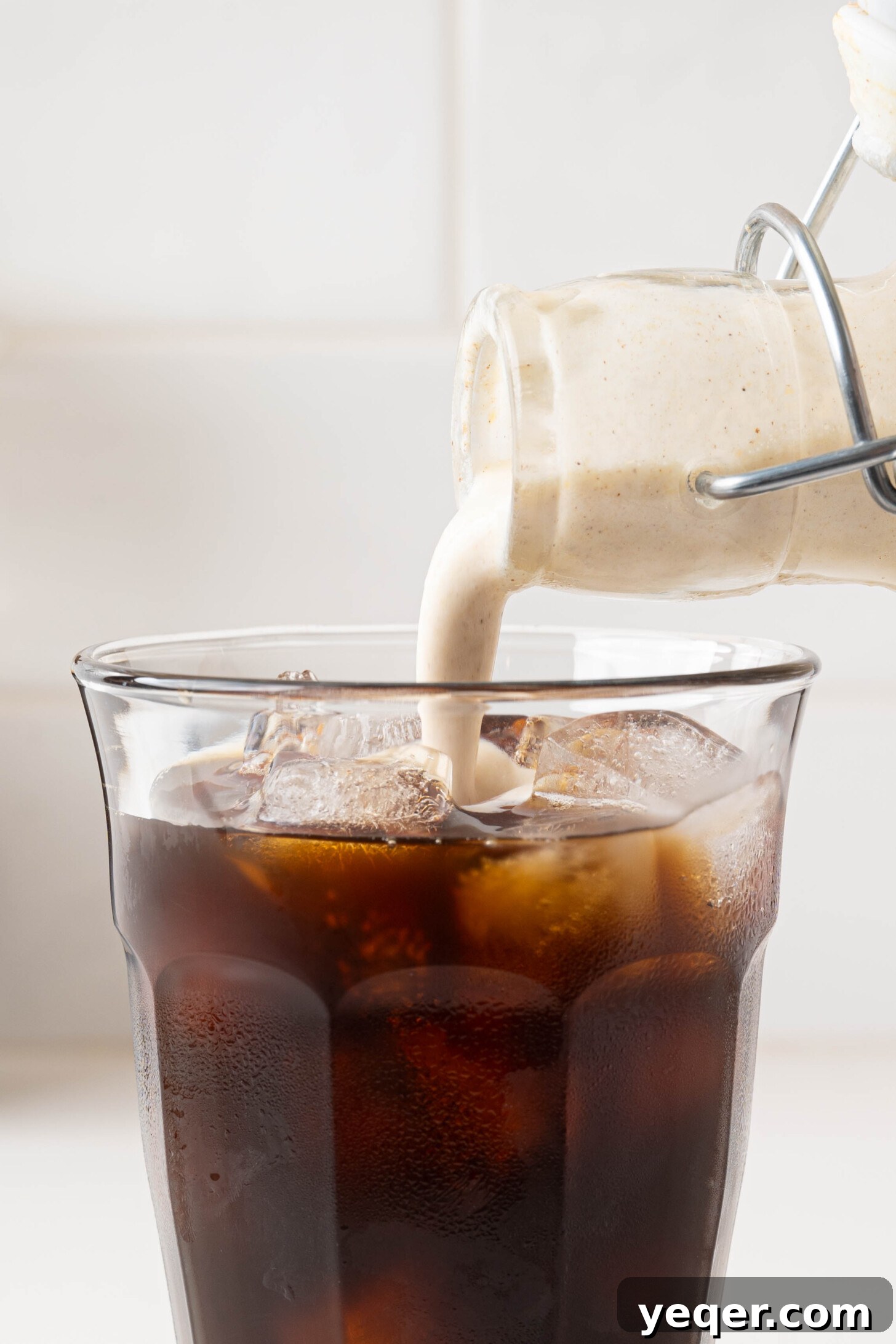 Homemade Five-Ingredient Pumpkin Spice Cold Foam 9 Pumpkin cold foam pouring over cold brew, showing perfect texture.