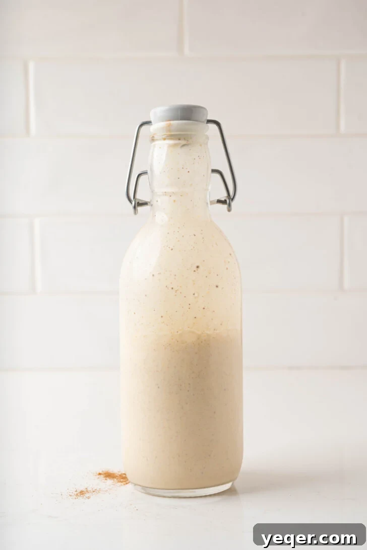 Homemade Five-Ingredient Pumpkin Spice Cold Foam 6 Pumpkin cold foam in a bottle, showing fluffy texture.