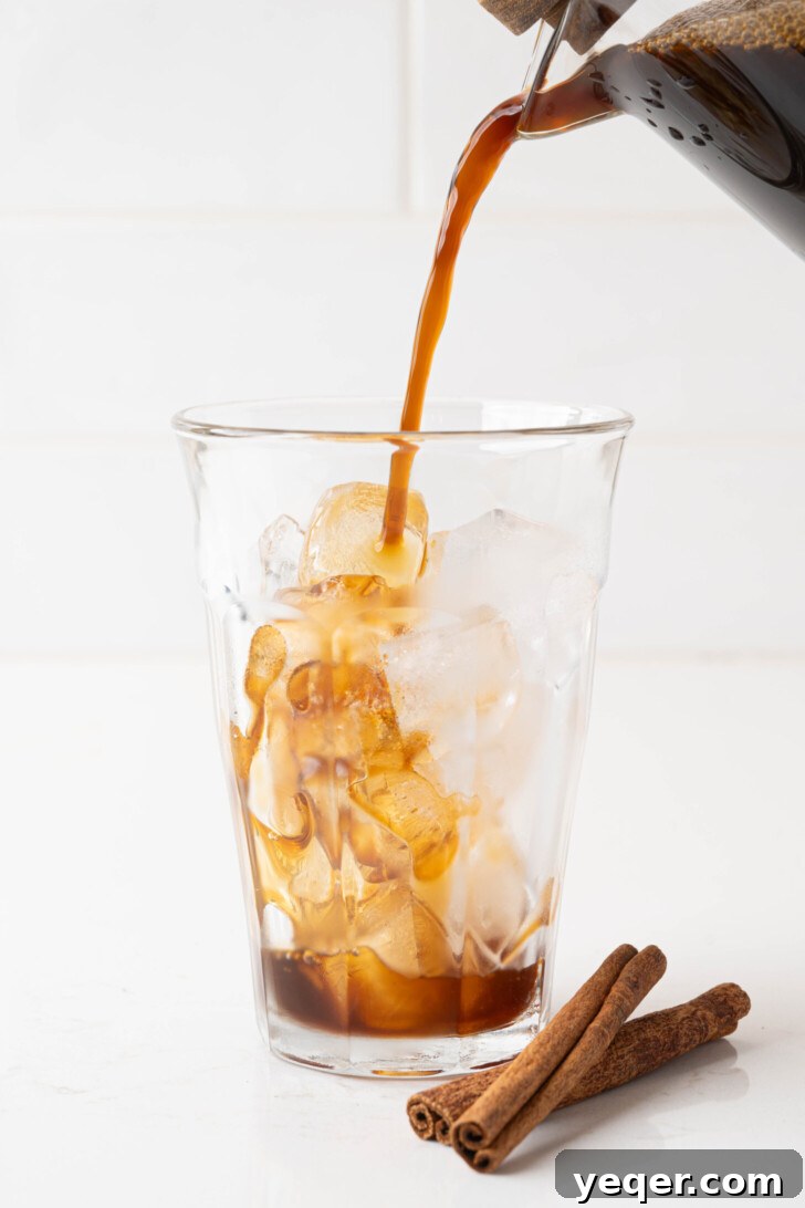 Homemade Five-Ingredient Pumpkin Spice Cold Foam 7 Coffee pouring into a glass of ice, ready for cold foam.