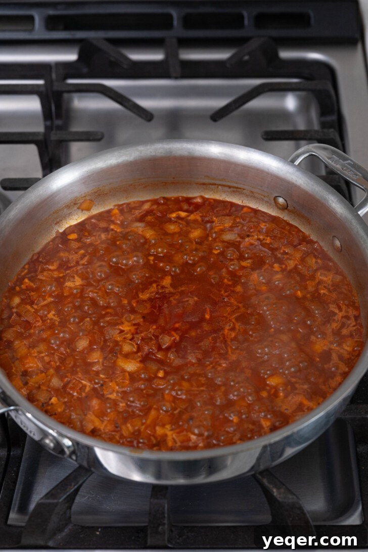 Fiery Spanish Patatas Bravas 6 Salsa brava simmering in a pan, thickening to the desired consistency.