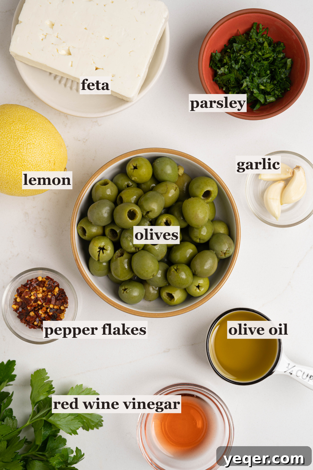 Exquisite Marinated Olives 3 Bowls showcasing the fresh, vibrant ingredients for marinated olives: olives, fresh parsley, whole garlic cloves, bright lemon, chili flakes, and crumbled feta cheese.