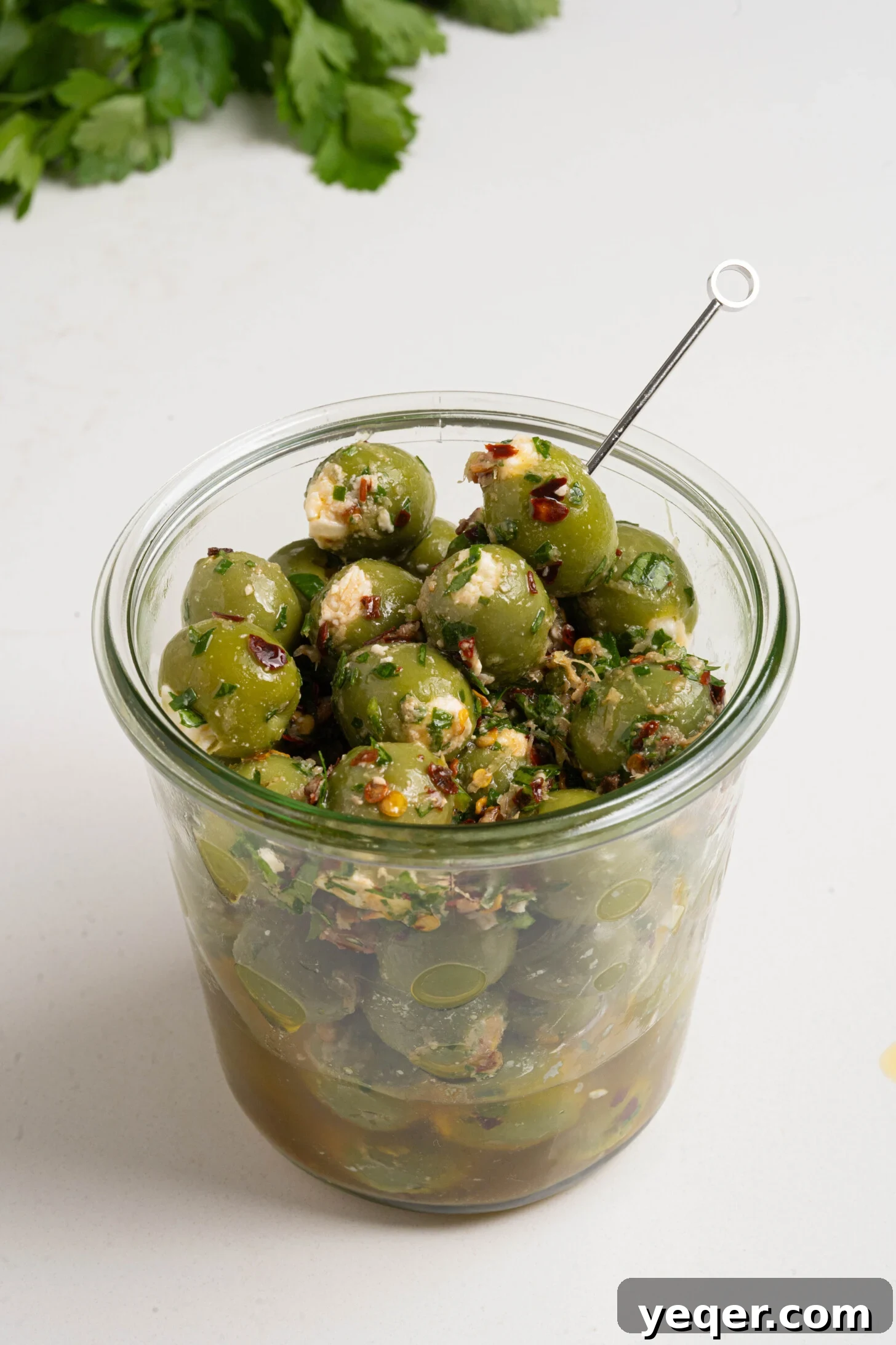 Exquisite Marinated Olives 6 Beautifully marinated and generously stuffed olives stored in a clear glass jar, showcasing their vibrant colors and readiness for serving.