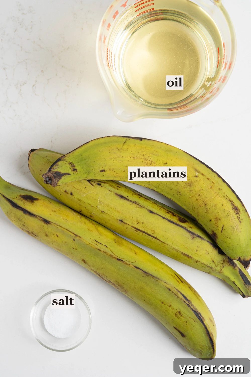 Crispy Plantain Delights 4 Essential ingredients: green plantains, cooking oil, and salt arranged for the recipe.