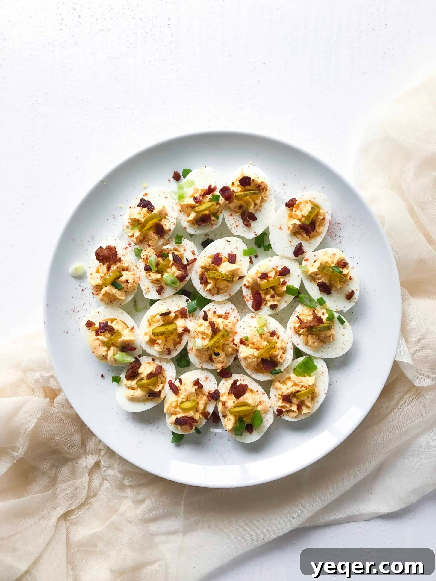 Heavenly Deviled Eggs 2 Loaded deviled eggs on a plate, garnished with paprika, scallions, and bacon