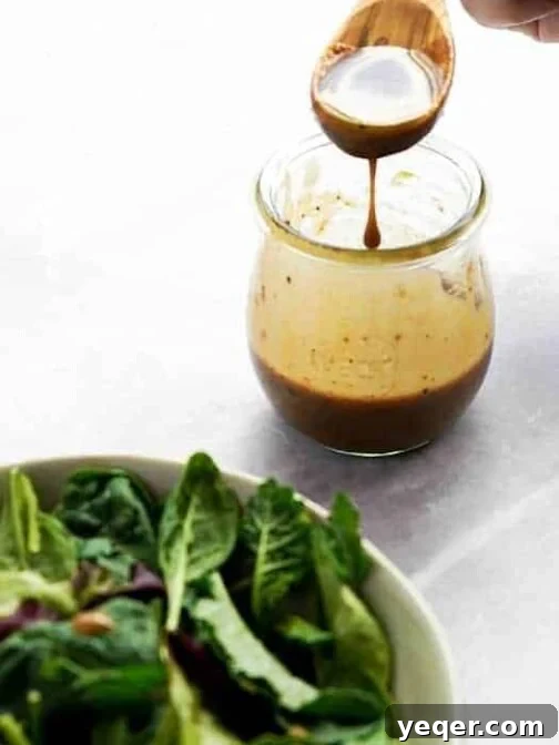 A jar of classic balsamic vinaigrette, ready to use on a fresh salad.