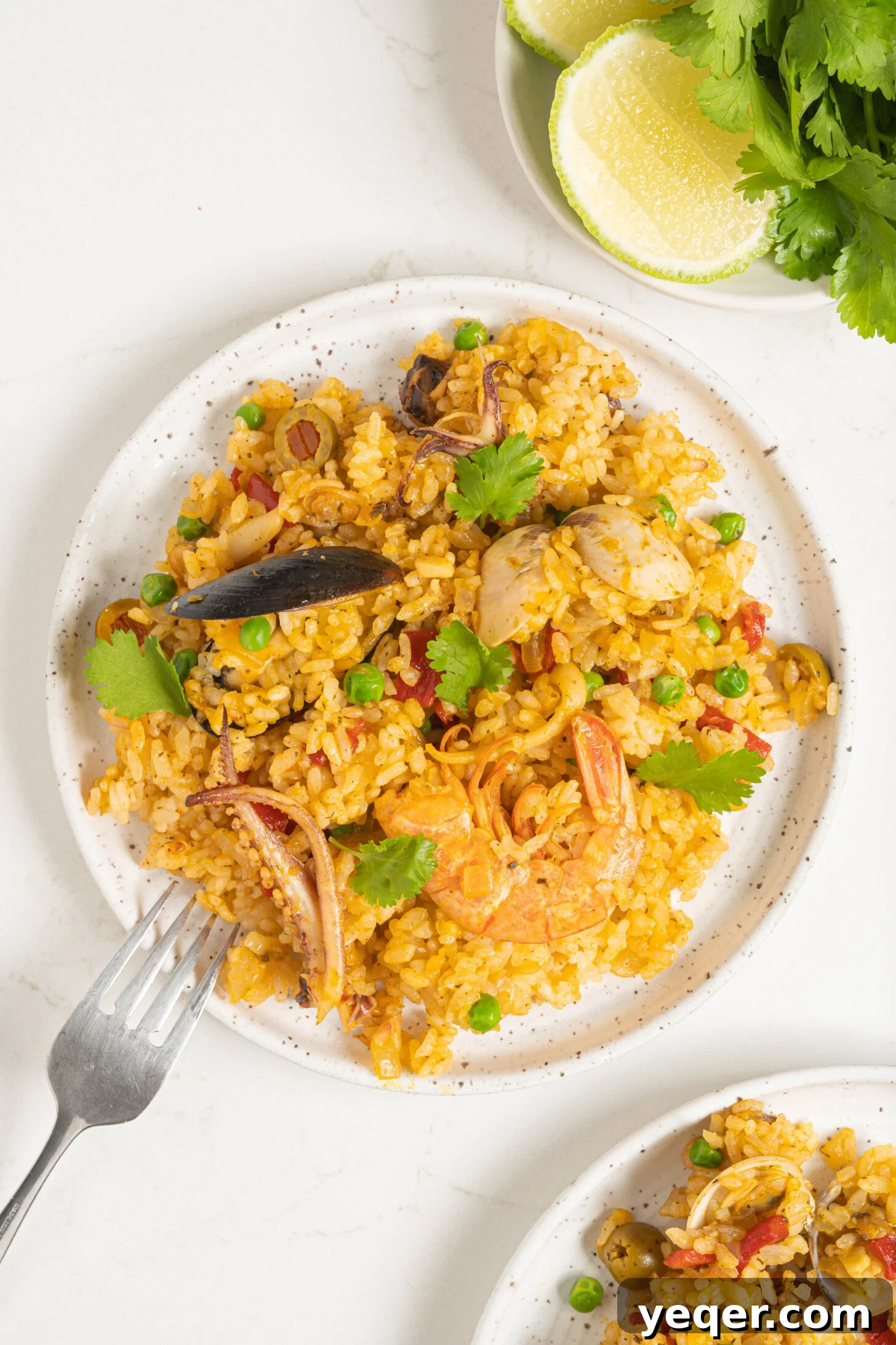 Vibrant Puerto Rican Seafood Rice 12 A vibrant plate of Puerto Rican seafood rice, garnished with fresh herbs and a lime wedge.
