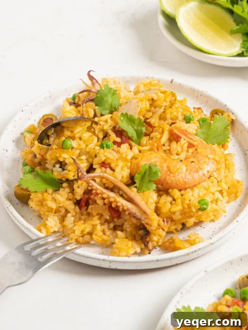 A plate of Puerto Rican seafood rice, garnished with fresh cilantro and a lime wedge, highlighting the vibrant colors and textures.