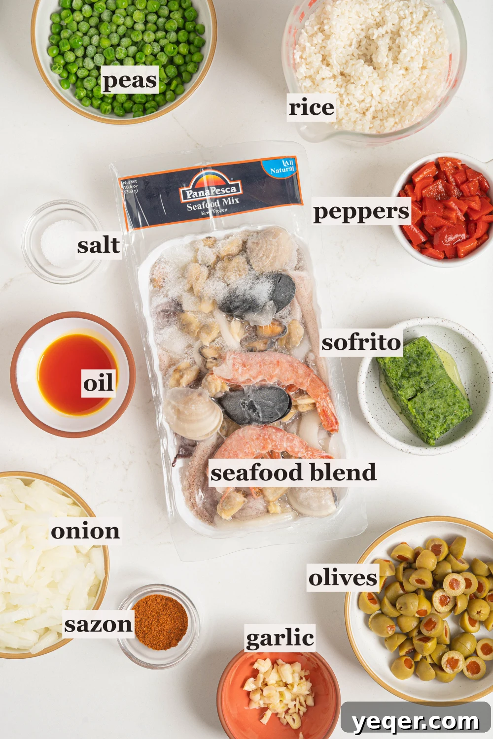 Vibrant Puerto Rican Seafood Rice 3 Various ingredients laid out for Puerto Rican seafood rice, including bowls of rice, frozen seafood mix, olives, onions, and spices.