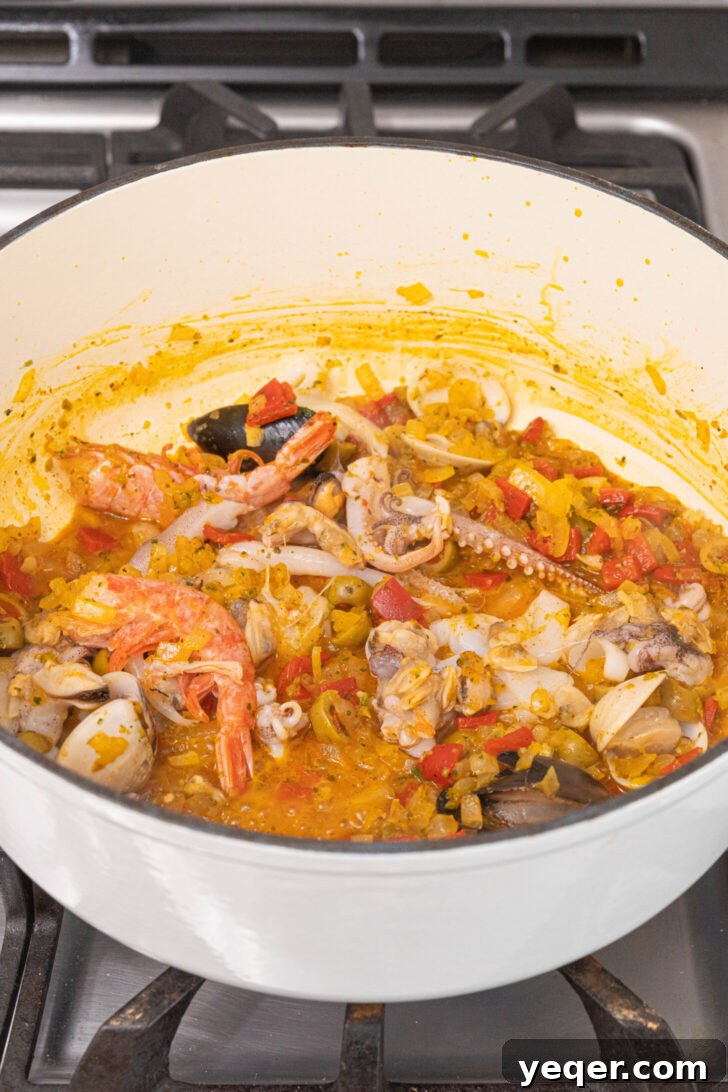 Vibrant Puerto Rican Seafood Rice 6 Thawed mixed seafood being added to the pot of sautéed vegetables and spices.