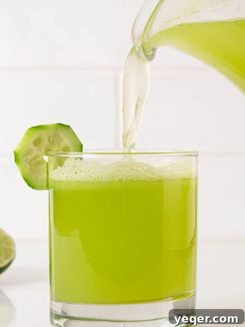 A glass of agua de pepino being poured, capturing its refreshing appeal and vibrant green color.