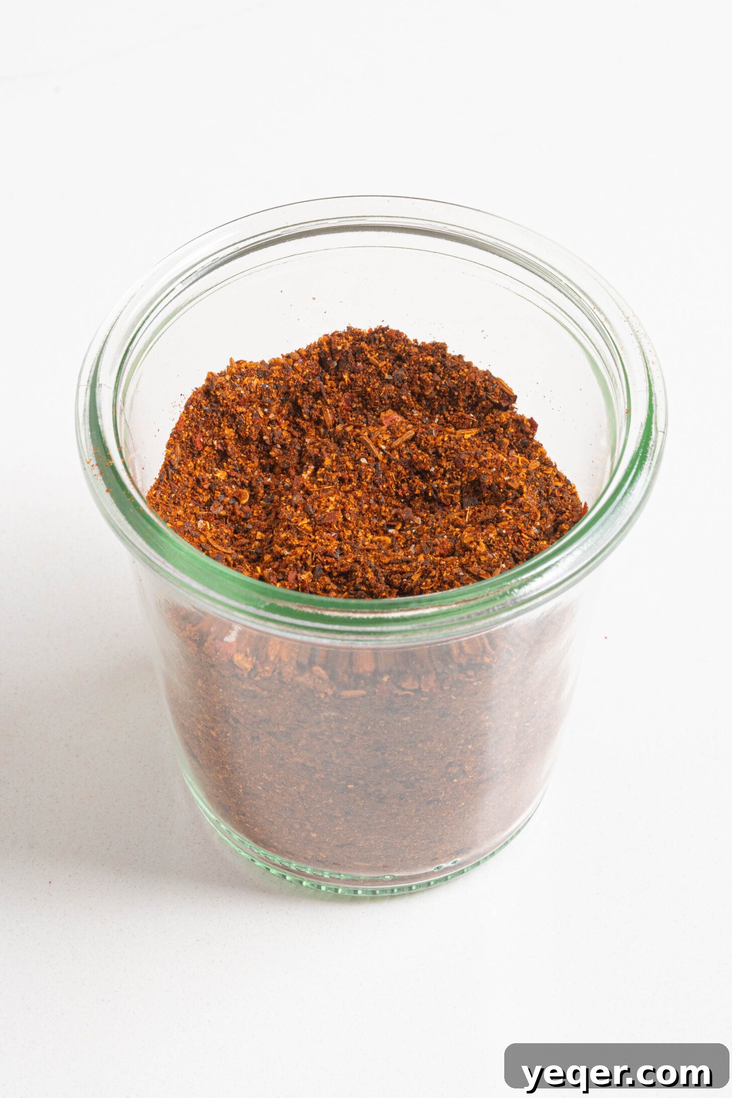 Homemade Harissa Spice Mix 10 A jar of homemade harissa seasoning displayed next to fresh ingredients.