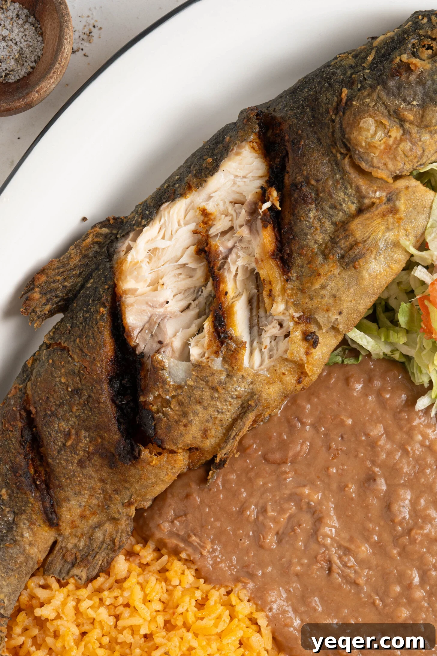 Crispy Whole Fried Mojarra 12 A festive platter showcasing Mojarra Frita alongside a generous serving of rice and beans, ready for a family meal.