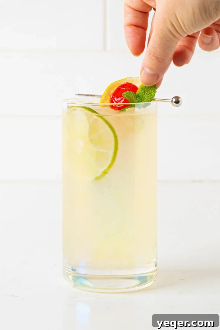 Authentic Mai Tai Cocktail 5 A freshly prepared Mai Tai cocktail, garnished with a mint sprig and lime wedge, on a white counter.