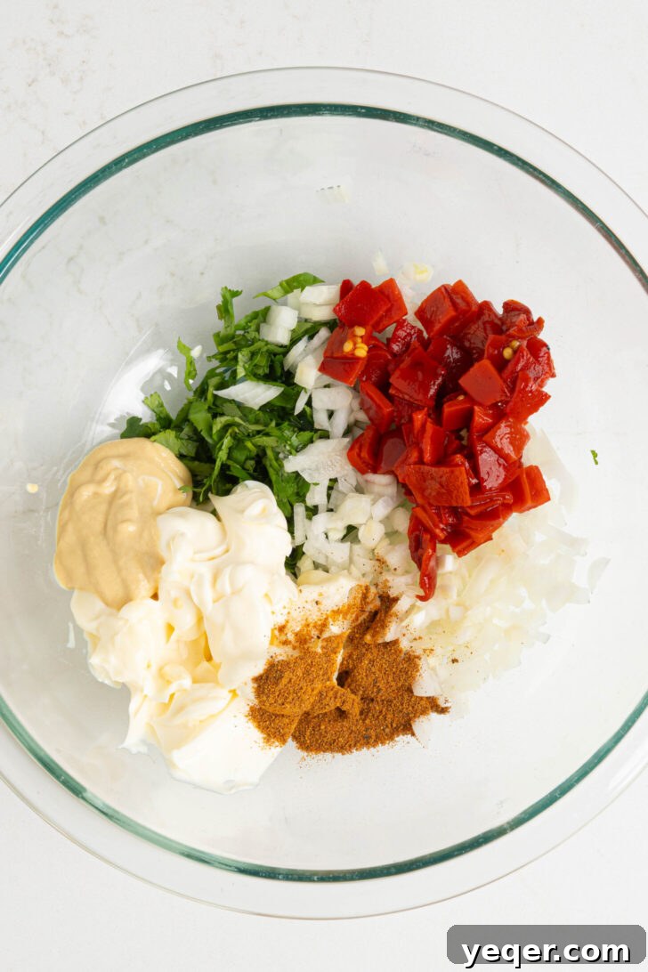 Puerto Rican Potato Salad 6 A bowl containing mayonnaise, mustard, chopped peppers, herbs, and other dressing ingredients.