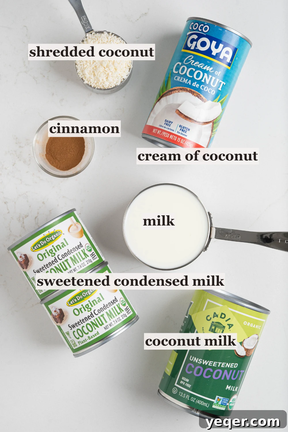 Puerto Rican Limber Coconut Pops 3 Ingredients laid out for making Limber de Coco, including cans of coconut milk, cream of coconut, sweetened condensed milk, and a bowl of shredded coconut.