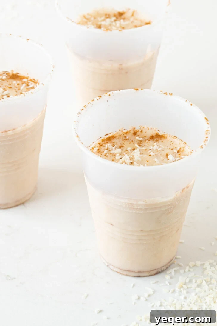 Puerto Rican Limber Coconut Pops 7 A hand gently squeezing the base of a plastic cup to release a frozen Limber de Coco, making it easy to enjoy.