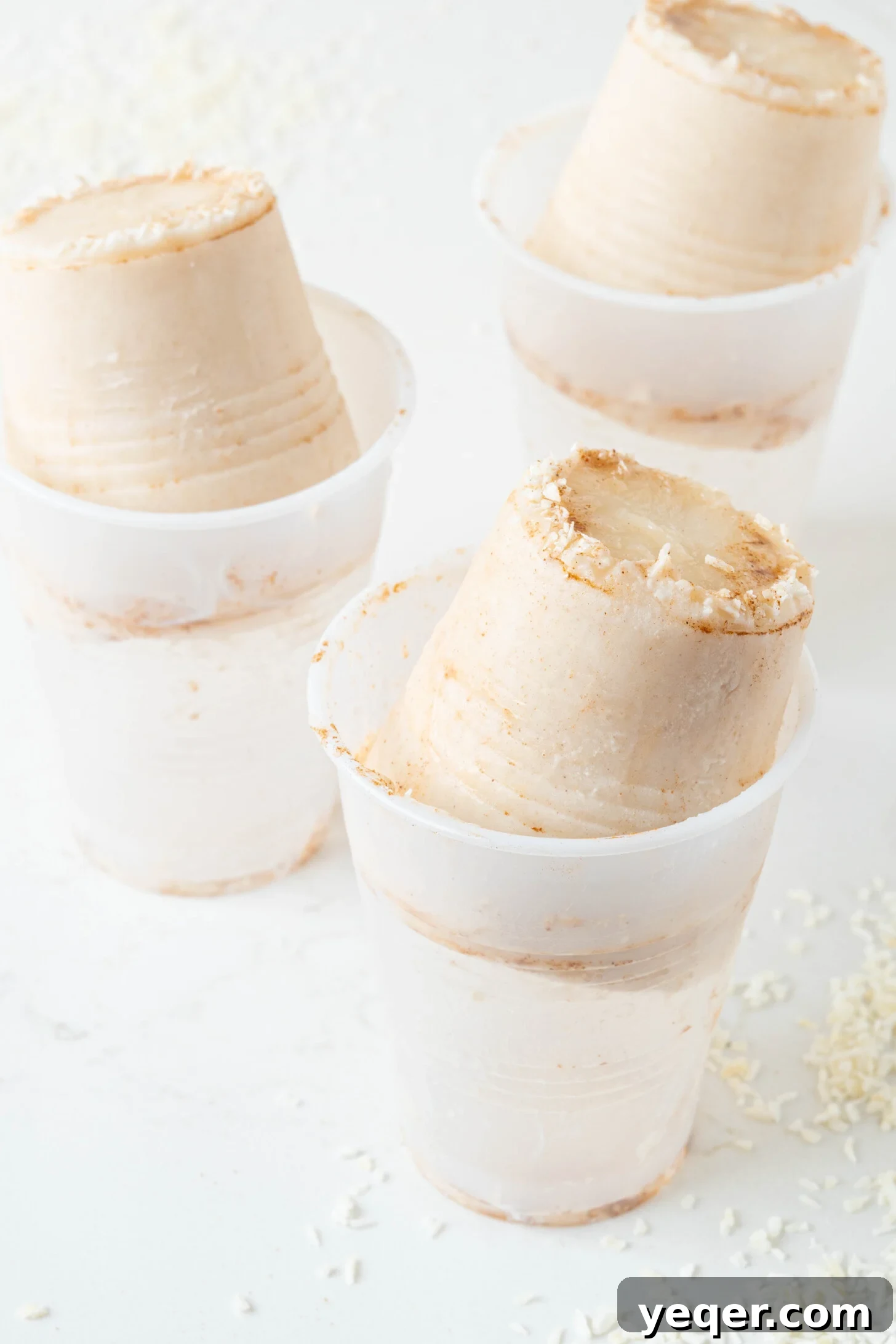Puerto Rican Limber Coconut Pops 8 A close-up shot of Limber de Coco in a plastic cup, showcasing its creamy texture and visible shredded coconut pieces.