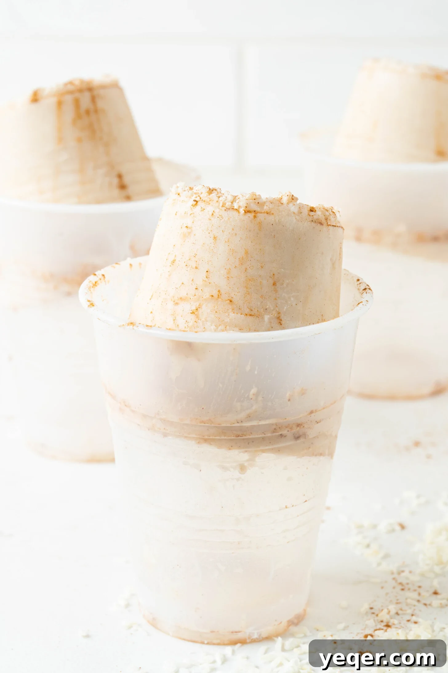 Puerto Rican Limber Coconut Pops 9 A hand holding a plastic cup with a Limber de Coco being squeezed up, highlighting the traditional method of enjoying this Puerto Rican treat.