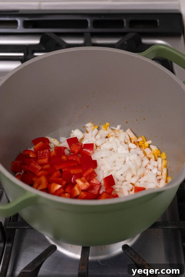 Caribbean Pigeon Pea & Rice Stew 4 A pot on the stove with diced onions and bell peppers sautéing in oil until translucent.
