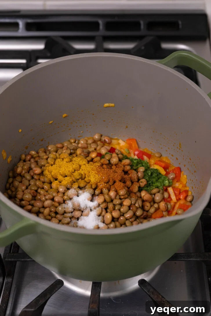 Caribbean Pigeon Pea & Rice Stew 5 A pot containing gandules, sofrito, and various spices, simmering gently.
