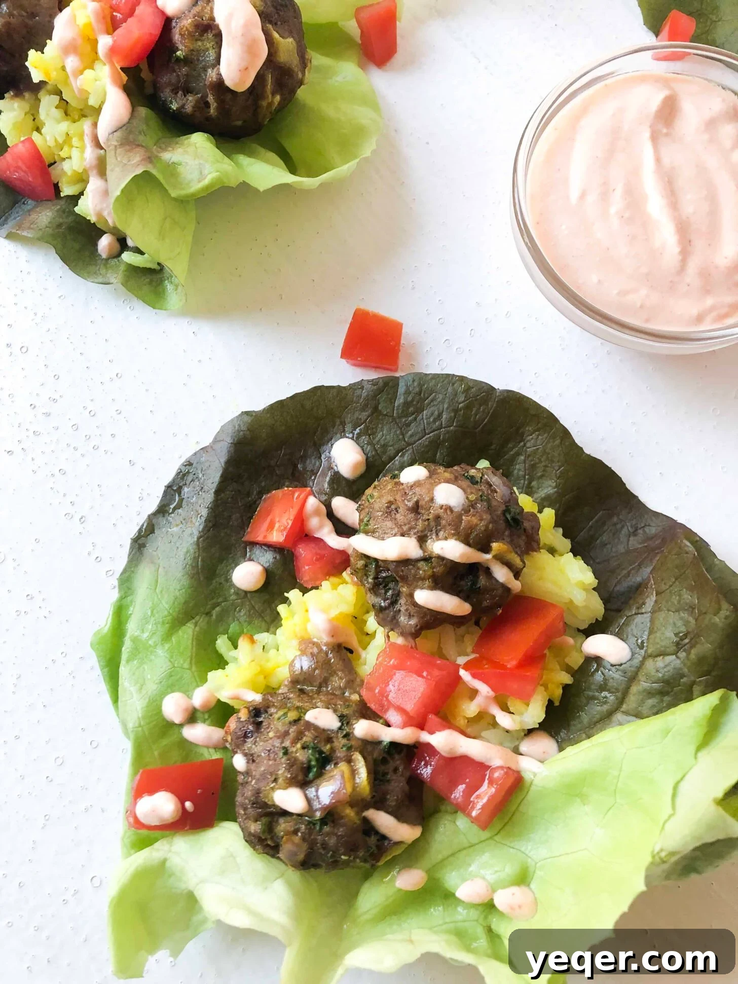 Aromatic Moroccan Kefta Lettuce Wraps 2 A vibrant Moroccan Kefta Lettuce Wrap bursting with spicy meatballs, fluffy rice, and a creamy harissa yogurt sauce, presented on a rustic plate.