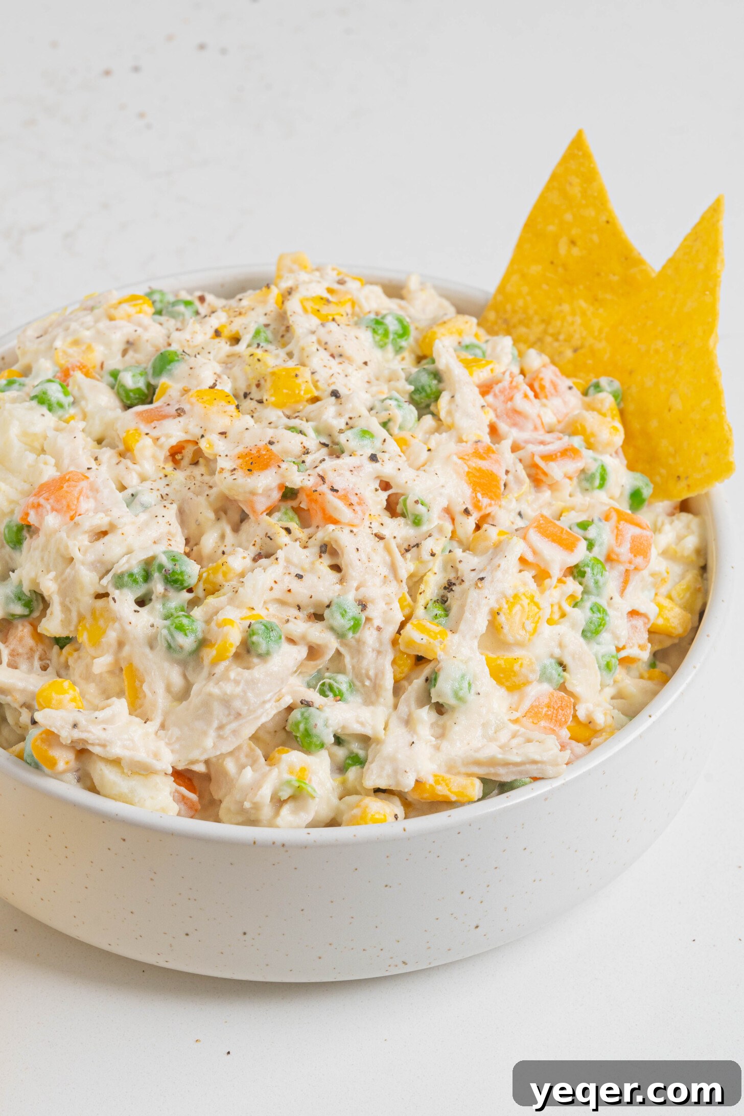Fiesta Chicken Salad 10 A generously sized bowl of Ensalada de Pollo, garnished with a sprig of fresh herb, ready to be served.