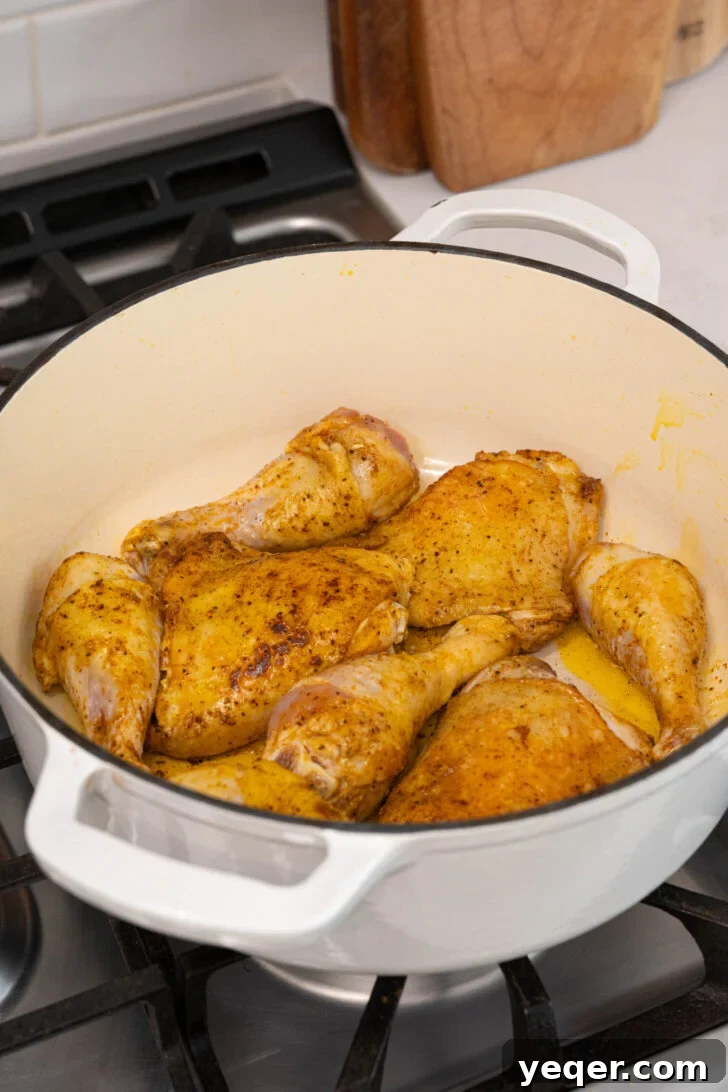 One-Pot Wonder Chicken Stew 5 Seasoned chicken searing to a golden brown in a large pot, preparing it for the stew.