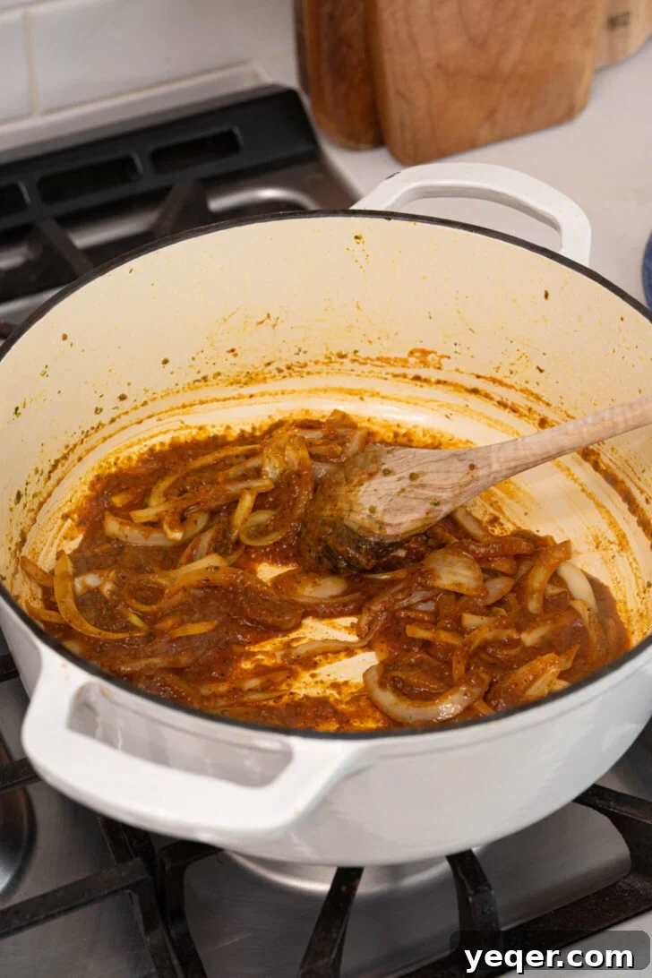 One-Pot Wonder Chicken Stew 6 Sautéing onions with spices and tomato sauce in a pot, building the rich base of the stew.