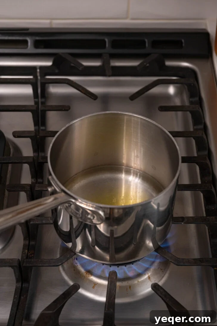 The Secret to Perfectly Fluffy Couscous 7 A small pot on a stove with water, oil, and salt, just brought to a boil.