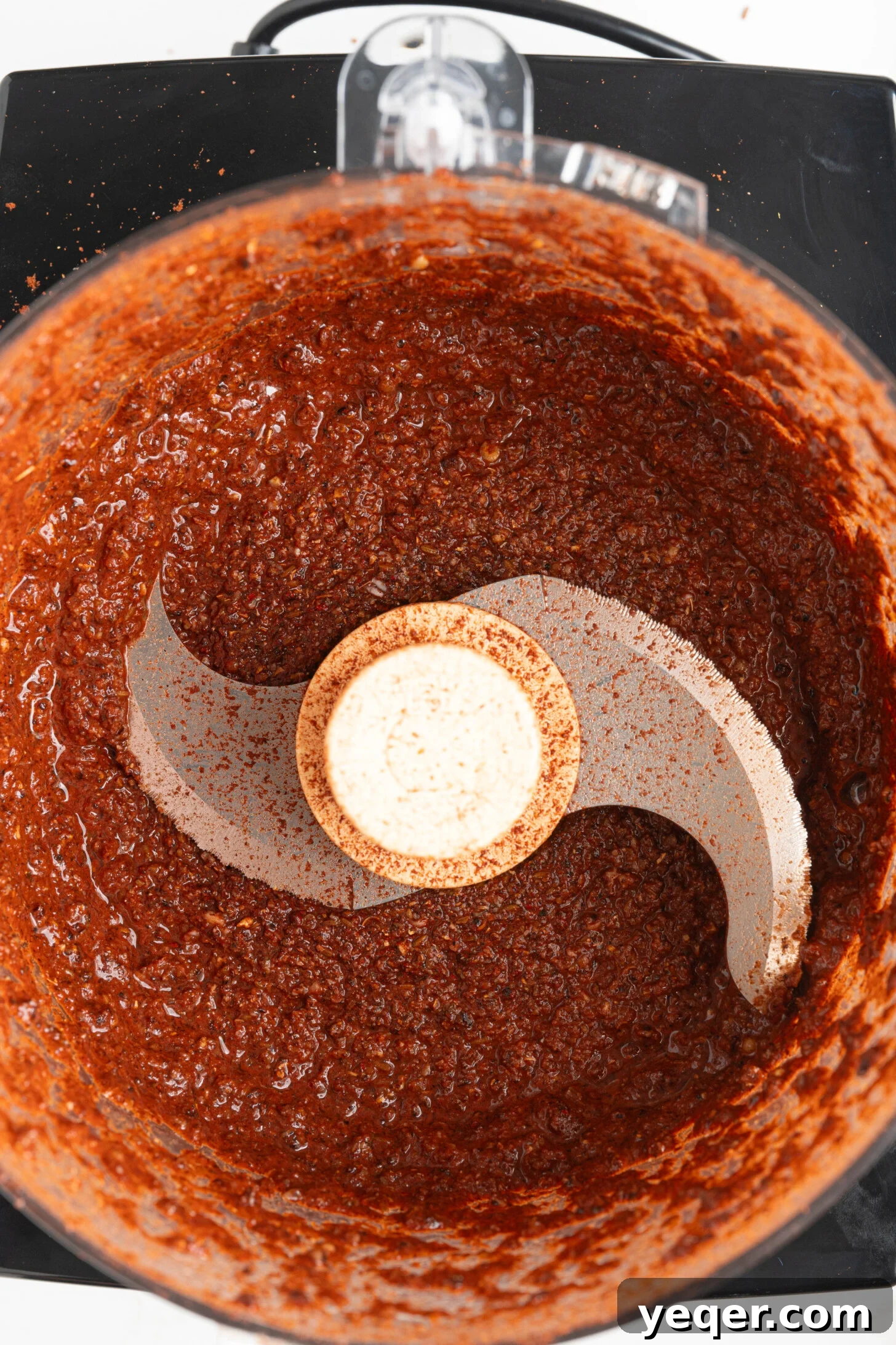Homemade Achiote Paste in Minutes 3 A food processor containing a rich, red-orange achiote paste, illustrating the perfect consistency.