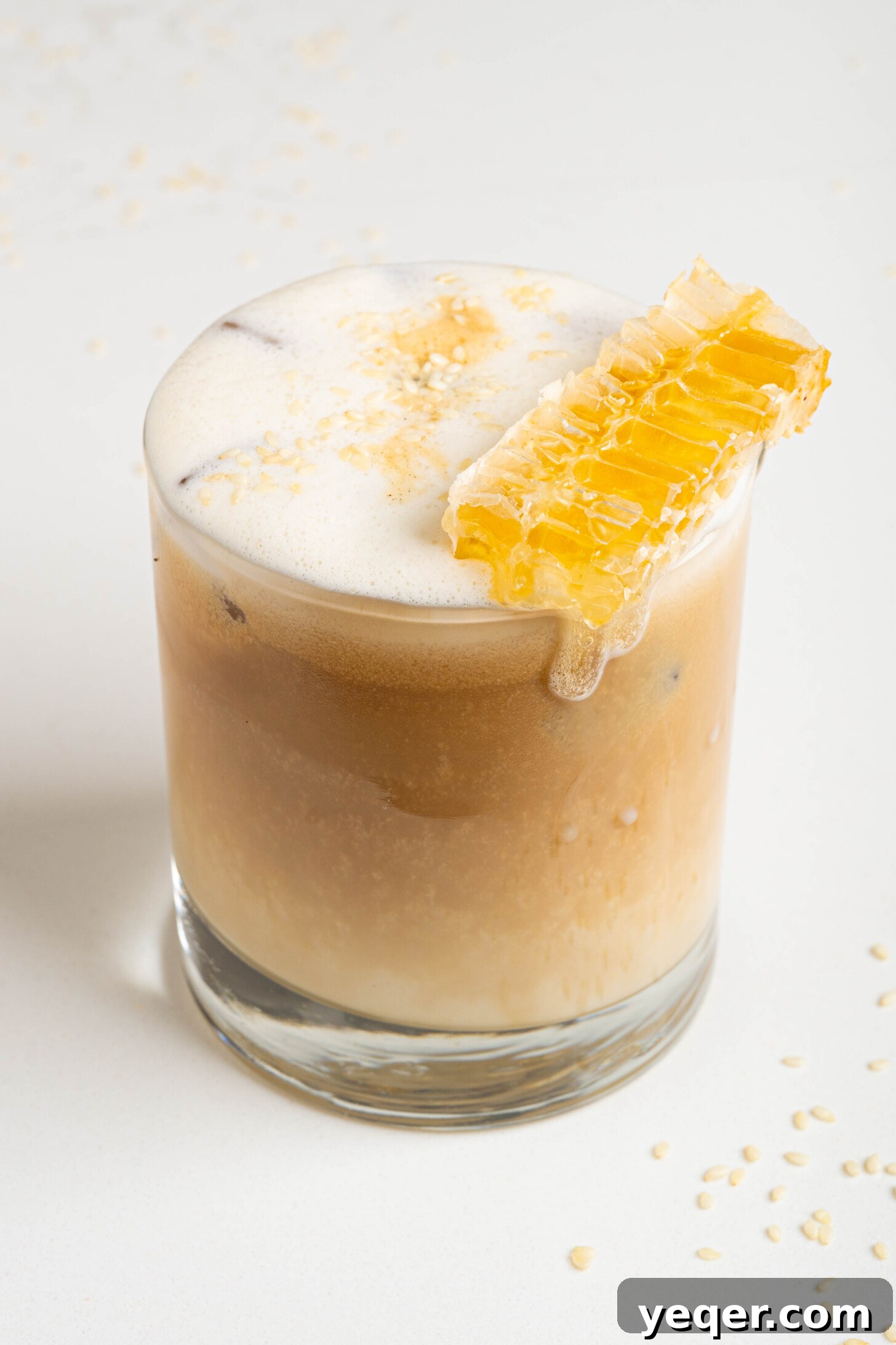 Salty Sweet Honeycomb Tahini Latte 9 A close-up shot of a perfectly frothed tahini latte in a glass, with a dusting of garnish on top, ready for drinking.