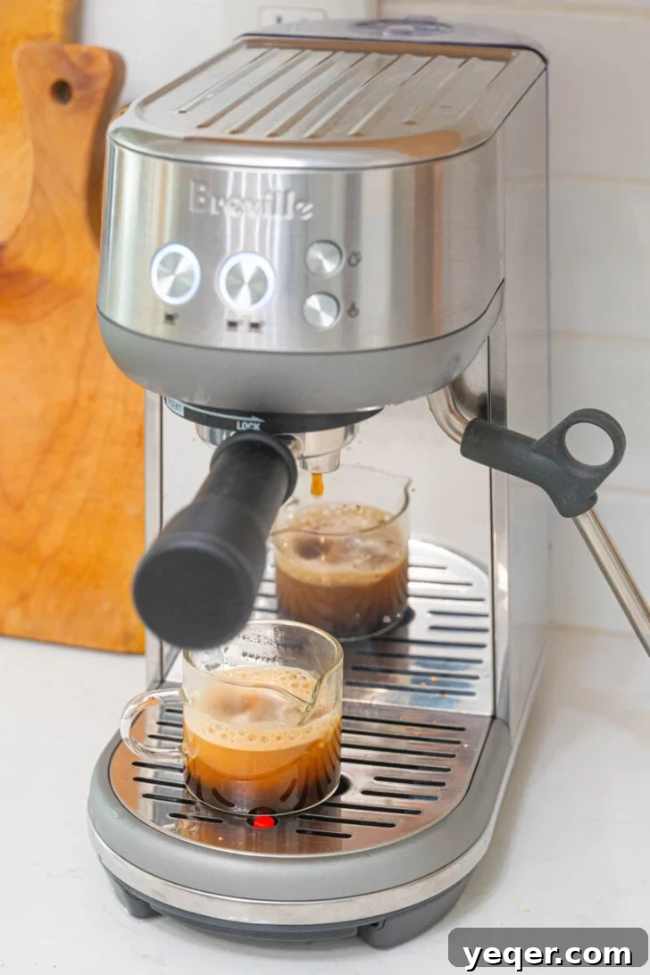 Salty Sweet Honeycomb Tahini Latte 4 Dark espresso brewing into a clear glass, creating a rich crema layer.