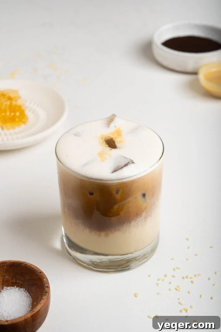 Salty Sweet Honeycomb Tahini Latte 6 A finished tahini latte in a glass, with the espresso gracefully layered over the frothed tahini milk, ready to be enjoyed.