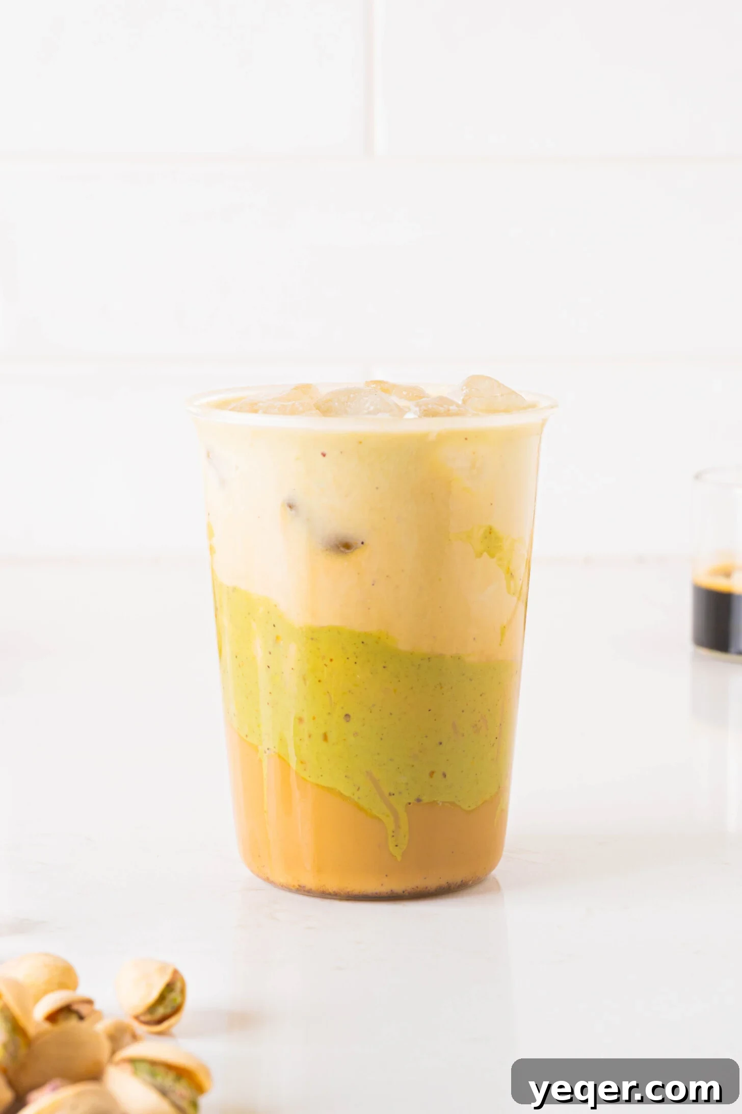 Signature Pistachio Dream Latte 9 A beautifully presented pistachio latte in a glass, ready to be enjoyed.