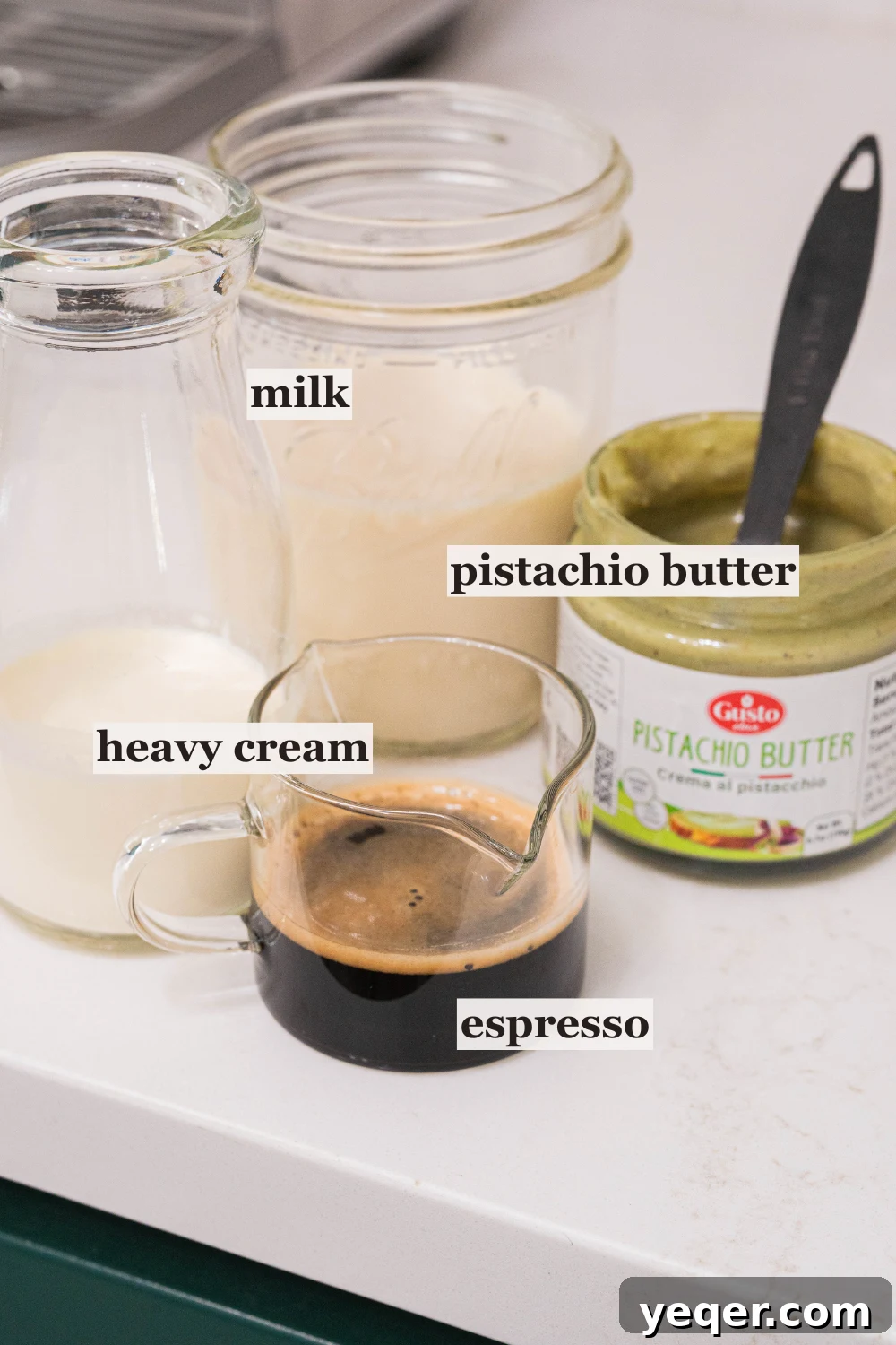 Signature Pistachio Dream Latte 4 Cups of heavy cream, milk, pistachio cream, and coffee beans, showcasing the main ingredients.