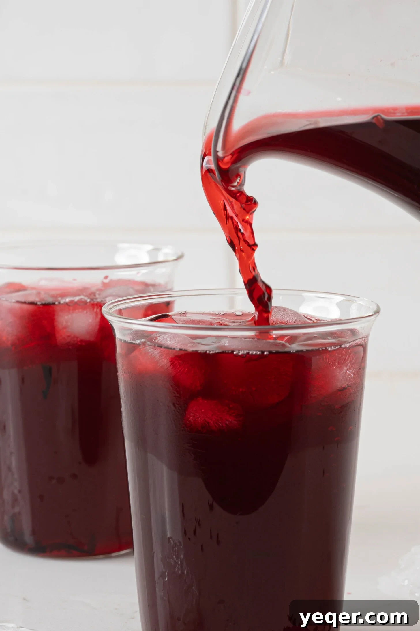 Agua de jamaica pouring into a glass.