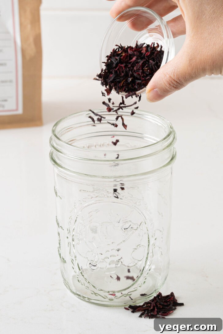 Hibiscus flowers sprinkling into a glass.