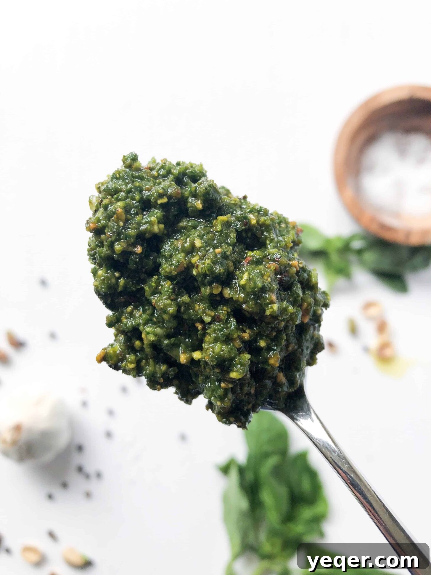 10-Minute Pistachio Pesto Magic 5 A close-up shot of a spoonful of chunky pistachio pesto, highlighting its rich texture and bright green color, ready to be enjoyed.