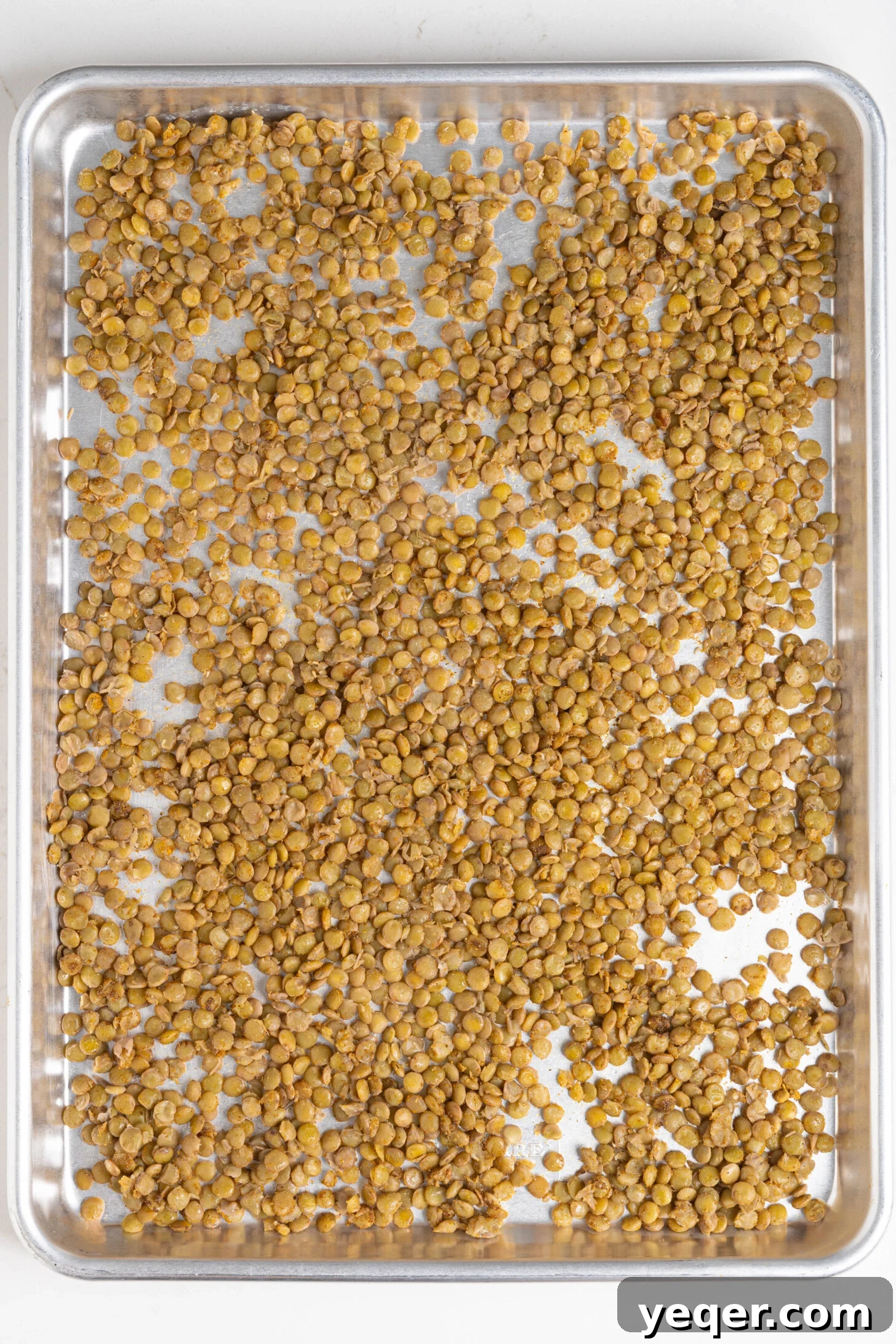 Golden Roasted Lentil Crisps 9 Spiced lentils on a baking sheet.