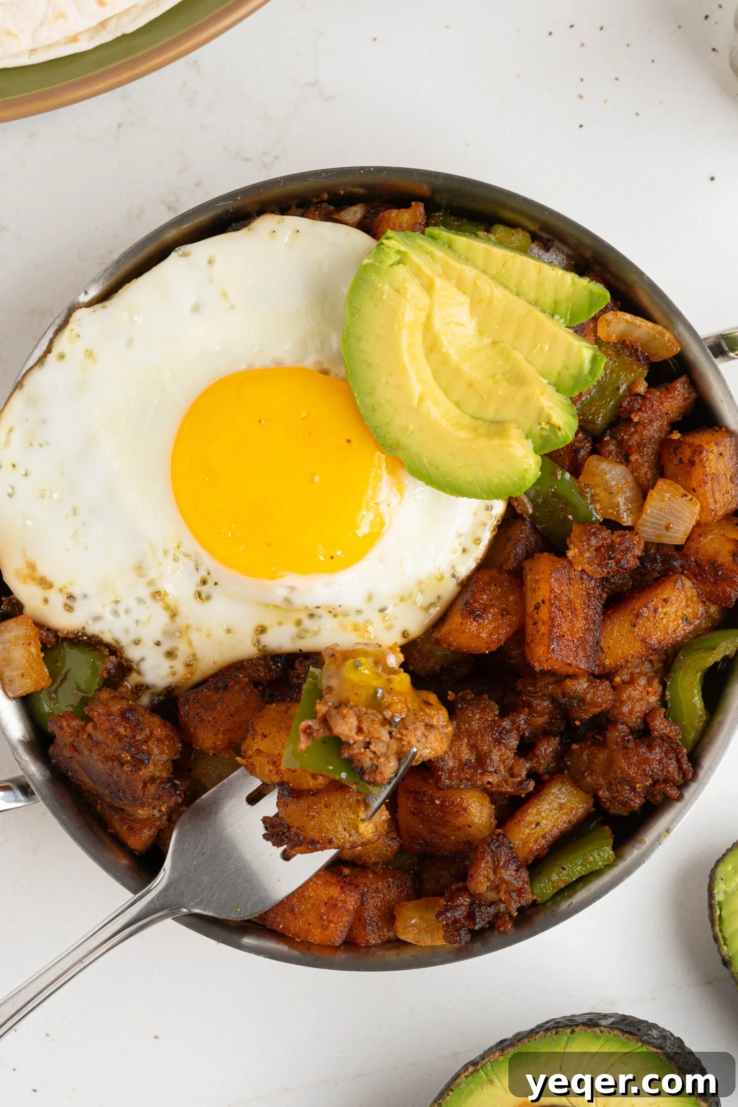 Savory Chorizo, Potato, and Egg Skillet 3 A large skillet filled with vibrant Chorizo Breakfast Hash, garnished with fresh herbs.