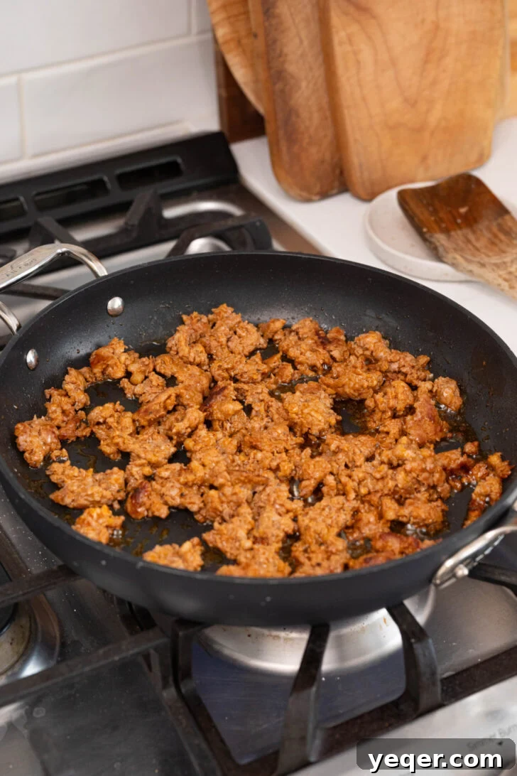 Savory Chorizo, Potato, and Egg Skillet 6 Crumbled chorizo browning in a hot pan, releasing its flavorful fat.