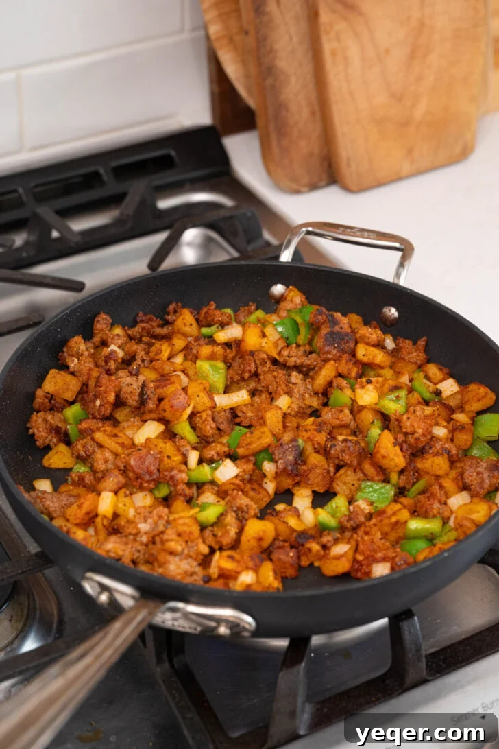Savory Chorizo, Potato, and Egg Skillet 8 All ingredients for the Chorizo Breakfast Hash are tossed together in a skillet, continuing to cook.