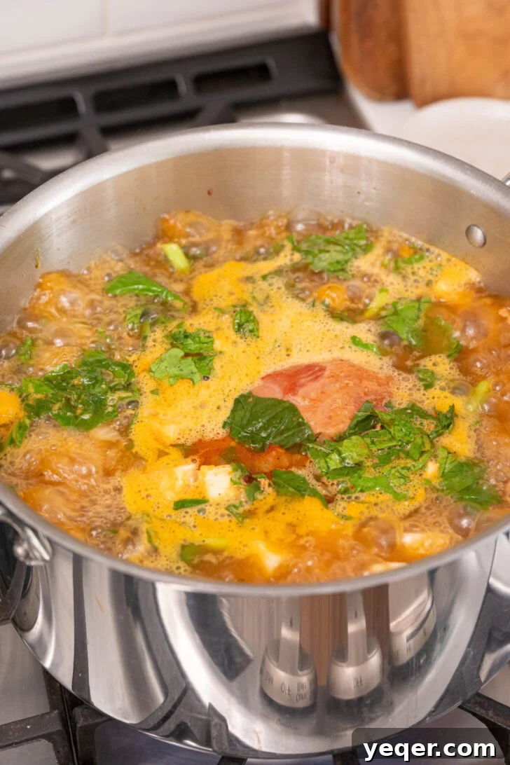 Hearty Galician White Bean Chorizo and Ham Caldo 7 The cooking chorizo returned to the pot with ham hock, turnip greens, white beans, and broth, ready for simmering.