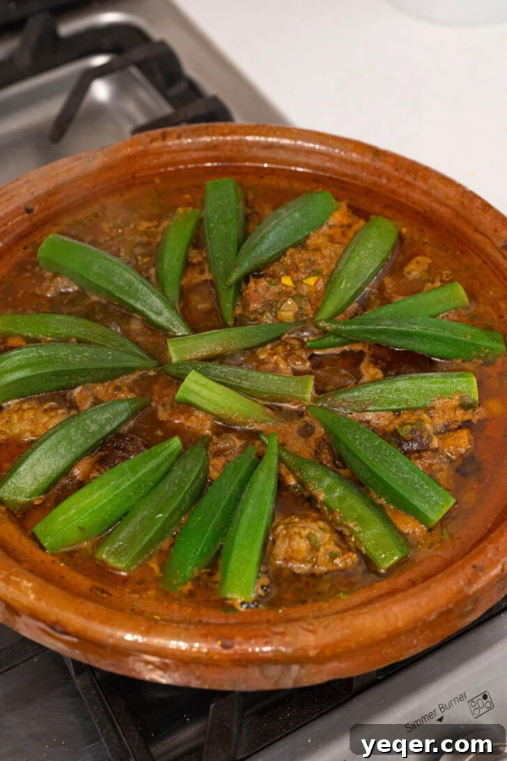 Moroccan Tagine with Okra and Tomatoes 7 A tagine with okra pods arranged neatly over the beef and tomato stew, ready for simmering.