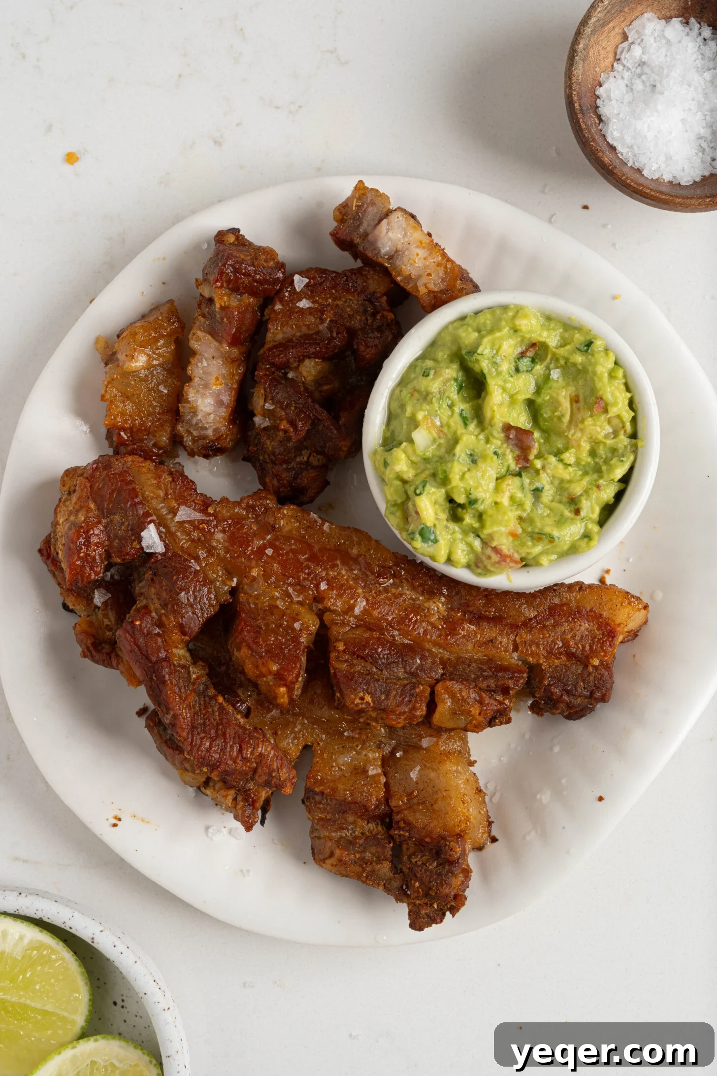 Crackling Oven-Roasted Pork Belly 10 Crispy chicharrones on a plate, with a fork, ready to be eaten.
