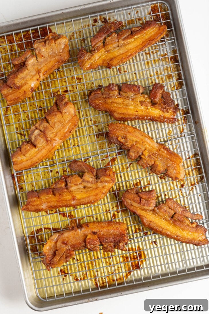 Crackling Oven-Roasted Pork Belly 5 Pork belly strips roasting in the oven at a low temperature.