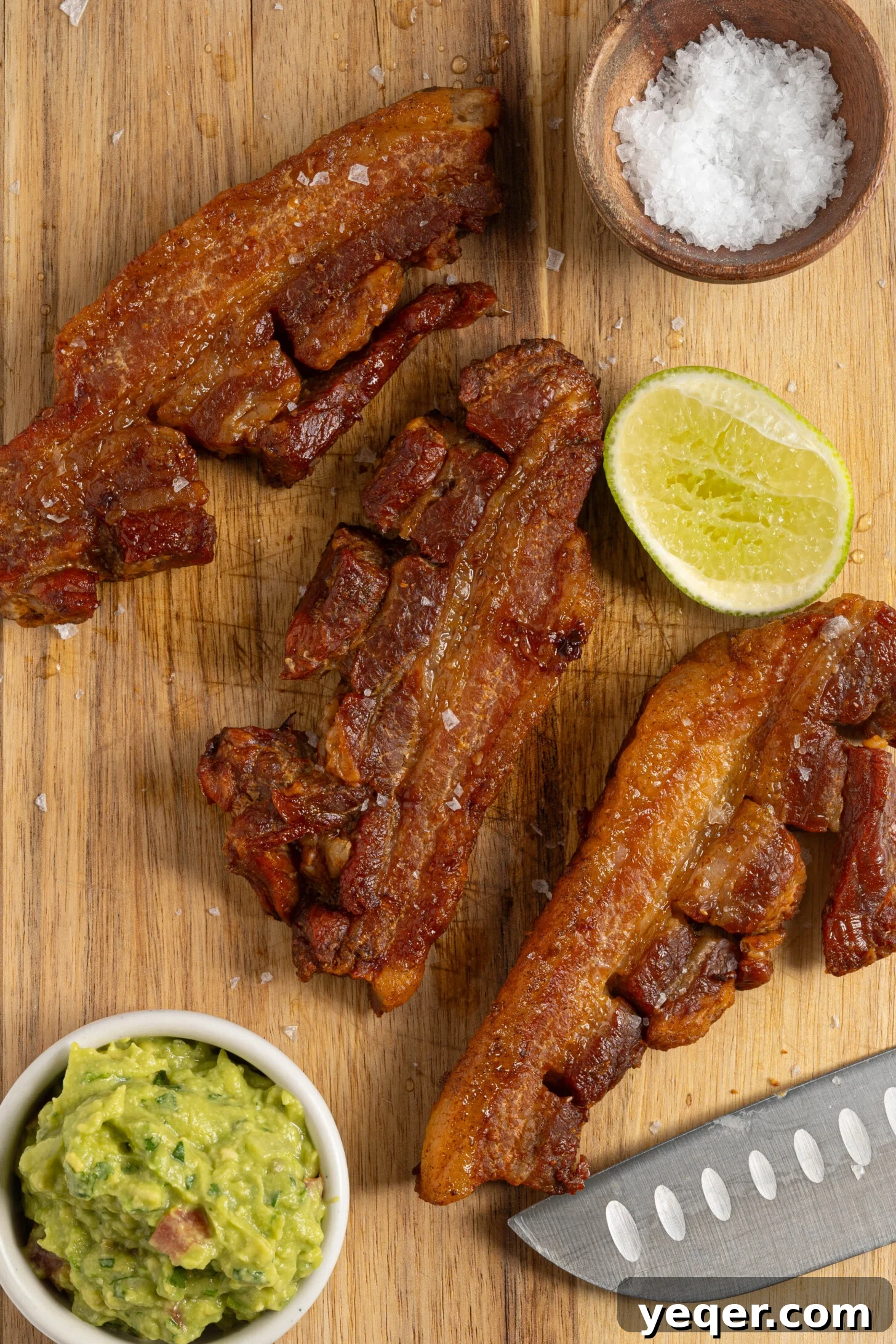 Crackling Oven-Roasted Pork Belly 7 Crispy pork belly on a wooden cutting board, ready to be sliced.