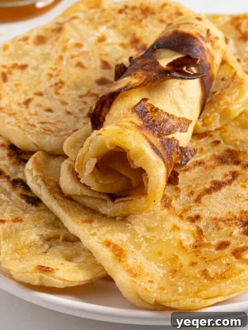 A plate full of Msmen, golden brown and flaky.