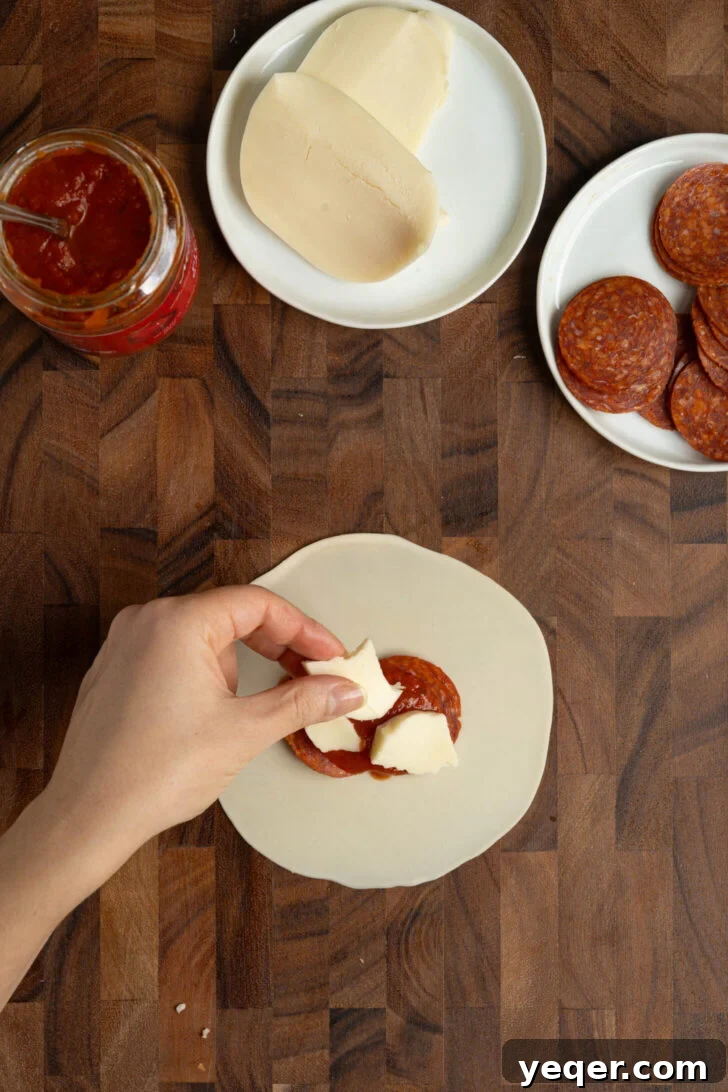Quick Pizza Pockets 4 Filling empanada dough with pizza ingredients: sauce, cheese, and pepperoni.